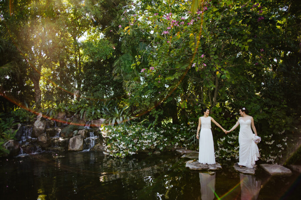 Two Brides standing in a pond at Colab Farms for their Destination Wedding