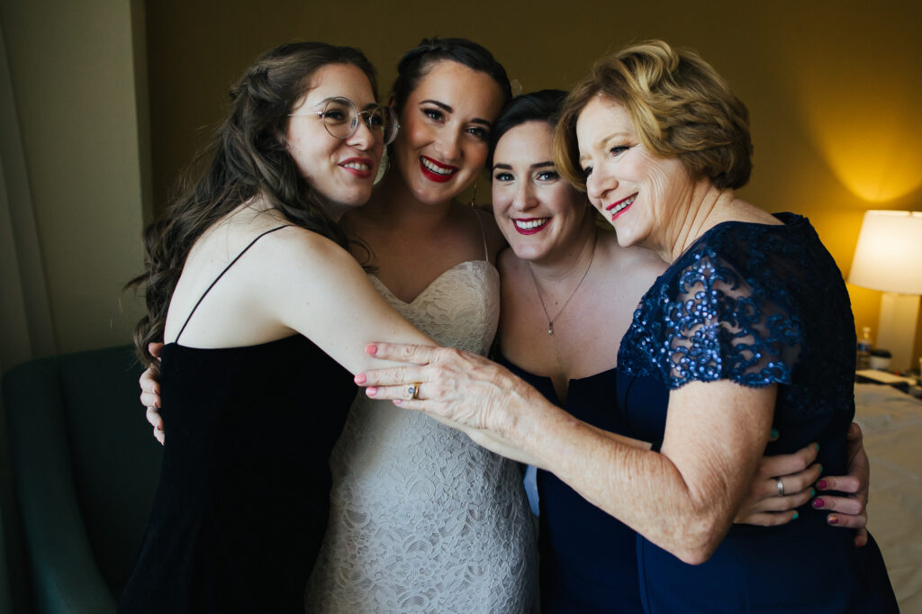 Bride hugging mom and sisters