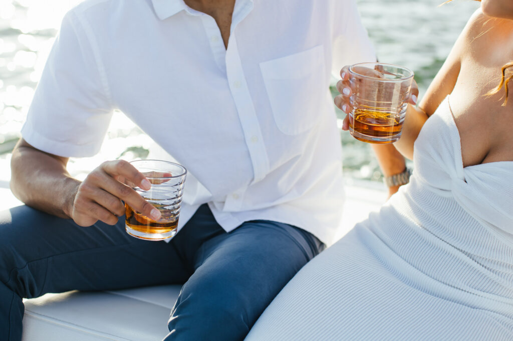 Couple holding drinks on a boat
