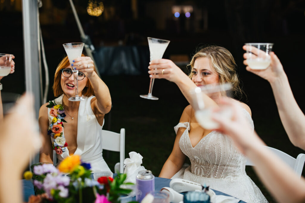 Brides raising a glass for a toast at their Destination Wedding Reception