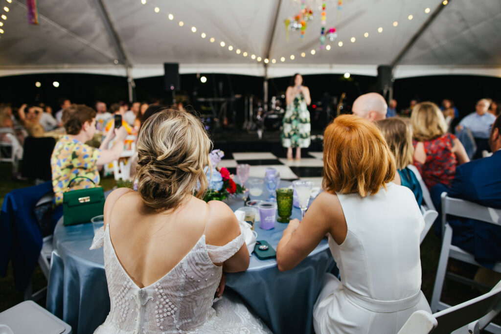 Brides listening to toasts and speeches at their Destination Wedding