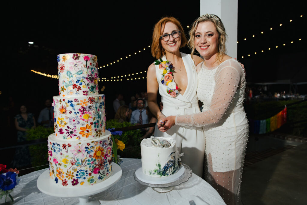 Two Brides cutting their Colorful Wedding Cake at their Destination Wedding in Alabama