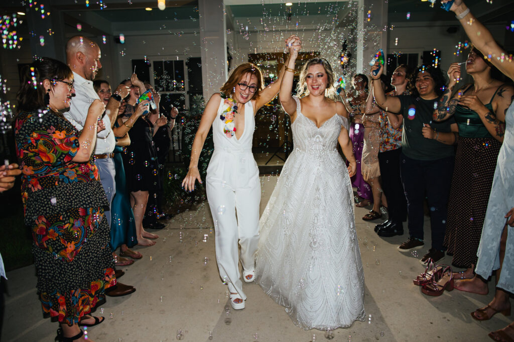 Two Brides walking through Bubbles after their Destination Wedding